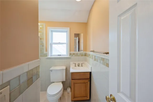 a bathroom with a toilet a sink and a mirror