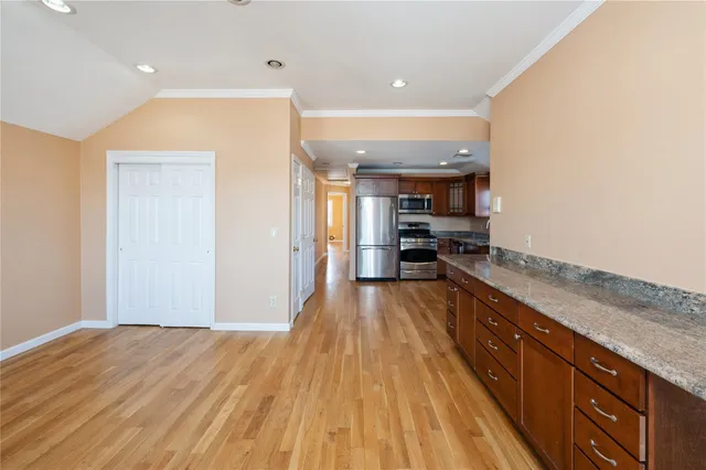 a large kitchen with stainless steel appliances granite countertop a refrigerator and a stove top oven