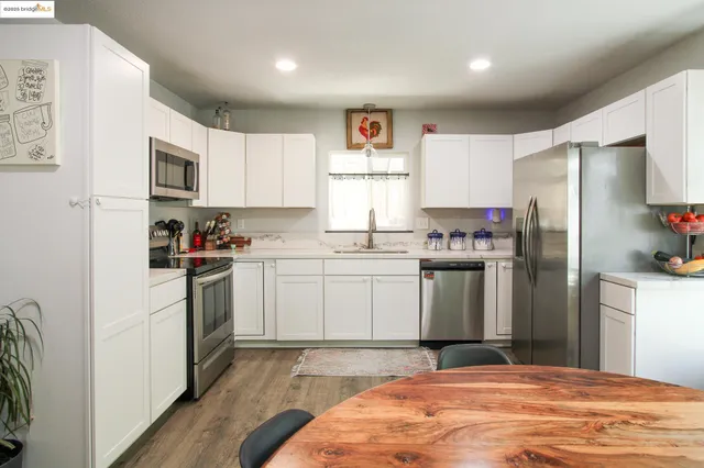 a kitchen with a refrigerator stove top oven and sink