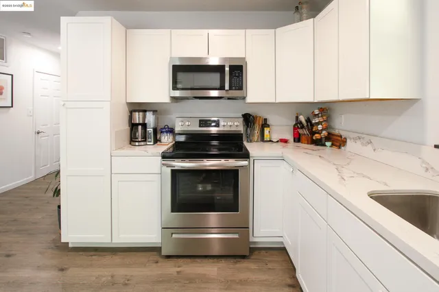 a kitchen with stainless steel appliances a stove a microwave and sink