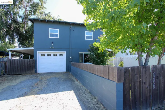 a view of a wooden house next to a yard