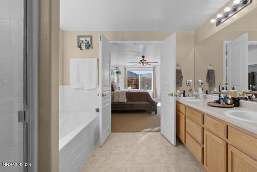 552 Spur Court Fernley, NV 89408 - Photo 28 of 46 a en suite bathroom with a double vanity sink a mirror and a bathtub