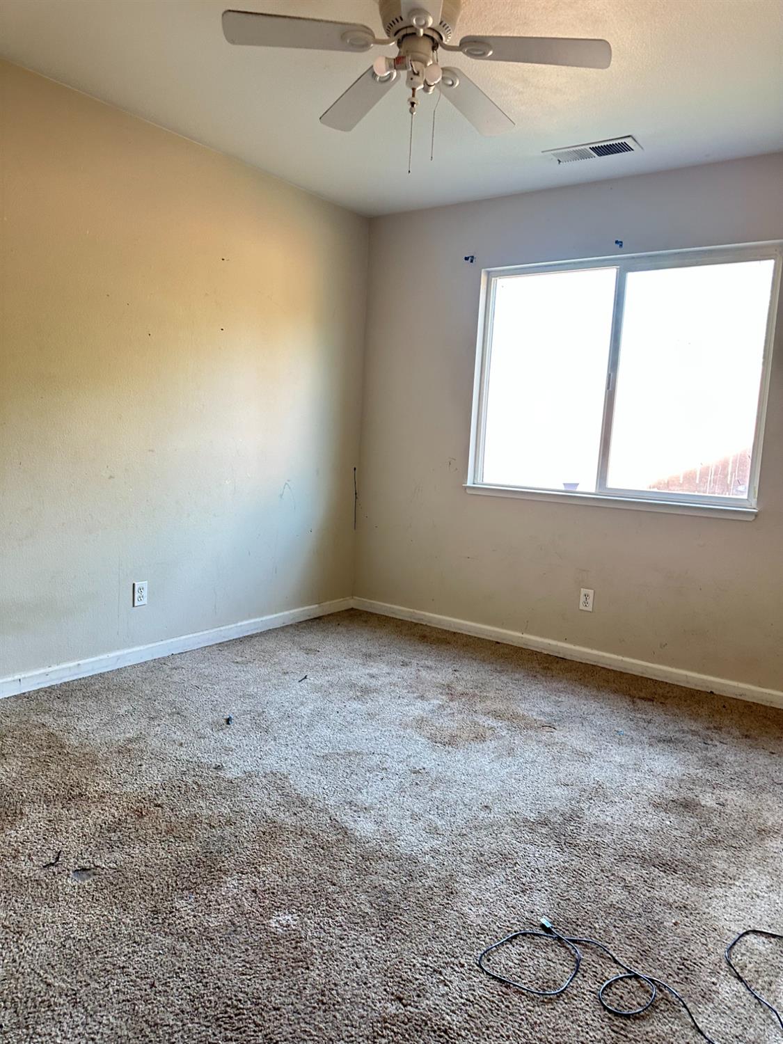 480 East 20th Street Chico, CA 95928 - Photo 9 of 11 an empty room with a window and ceiling fan