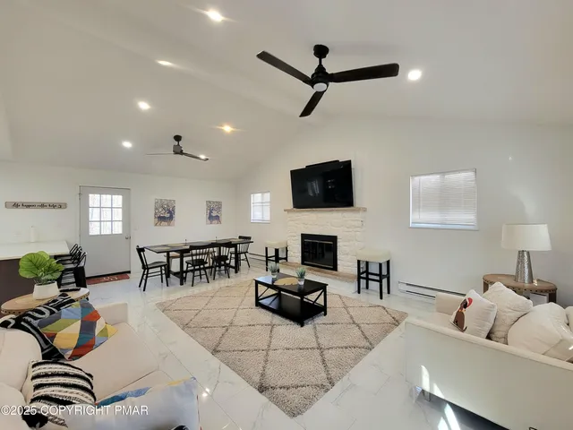 a living room with furniture and a flat screen tv with wooden floor