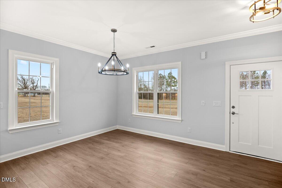 1300 Nick Coley Road Whitakers, NC 27891 - Photo 10 of 47 an empty room with wooden floor chandelier and windows