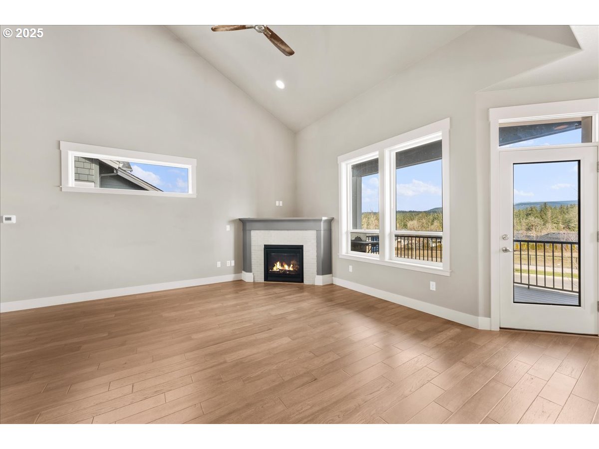 6452 Northwest Lambert Lane Camas, WA 98607 - Photo 8 of 43 a view of an empty room with wooden floor and a window
