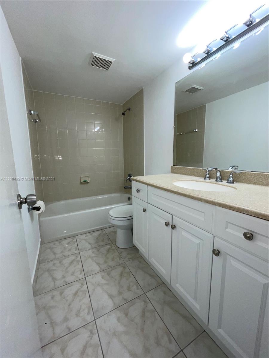 10802 Southwest 88th Street, Unit P2 Miami, FL 33176 - Photo 12 of 23 a bathroom with a double vanity sink toilet mirror and bathtub
