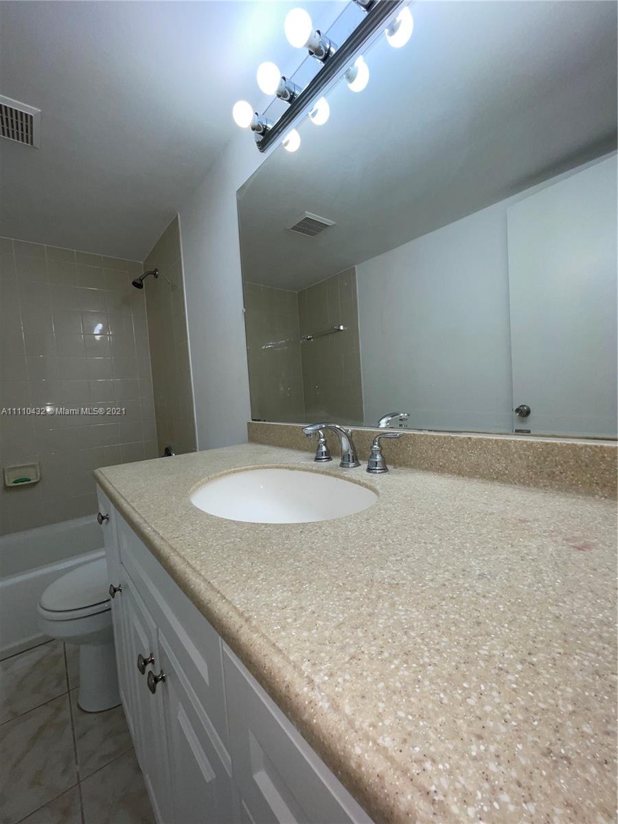 10802 Southwest 88th Street, Unit P2 Miami, FL 33176 - Photo 13 of 23 a bathroom with a granite countertop sink a toilet and a large mirror