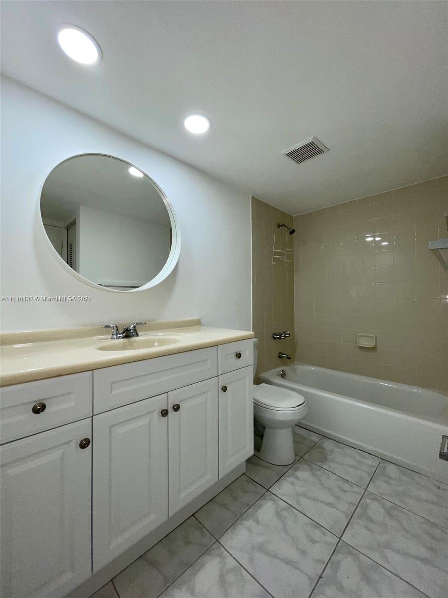 10802 Southwest 88th Street, Unit P2 Miami, FL 33176 - Photo 6 of 23 a bathroom with a toilet a sink and mirror