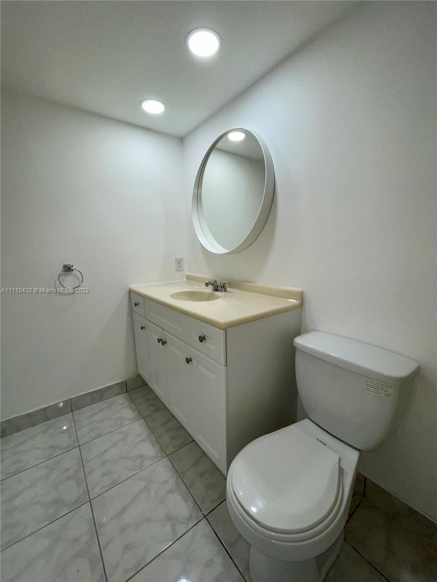 10802 Southwest 88th Street, Unit P2 Miami, FL 33176 - Photo 8 of 23 a bathroom with a toilet a sink and mirror