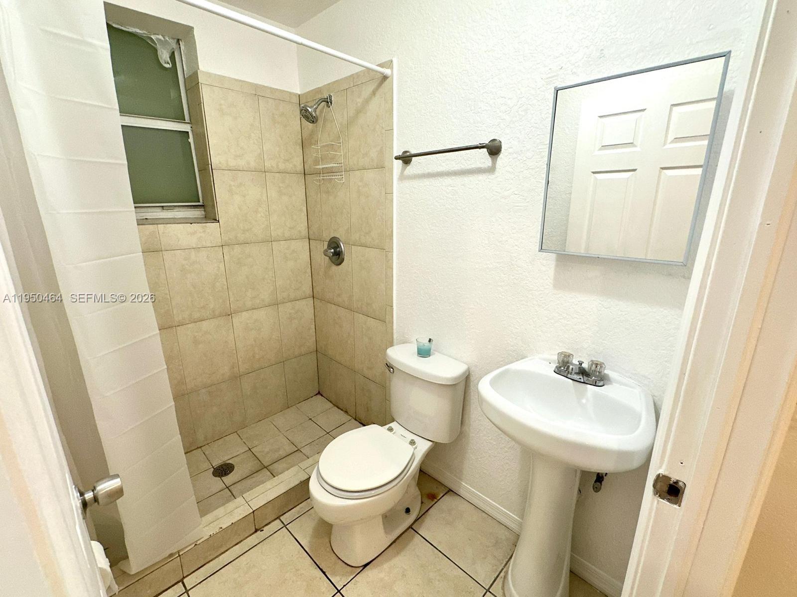 1021 Northwest 3rd Street, Unit 307 Miami, FL 33128 - Photo 9 of 13 a bathroom with a sink toilet and shower