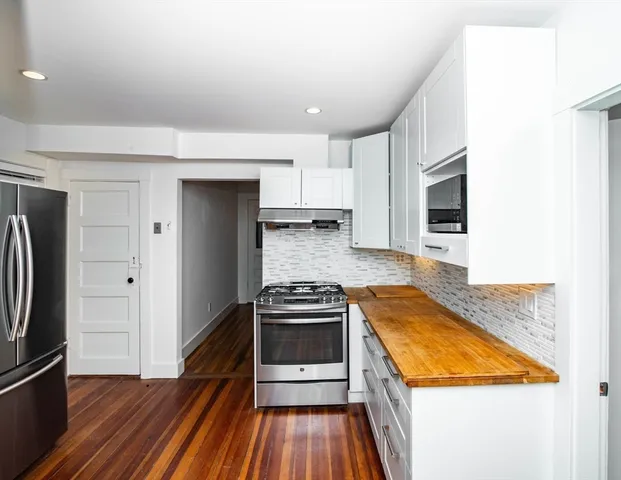a kitchen with wooden floor and a stove top oven