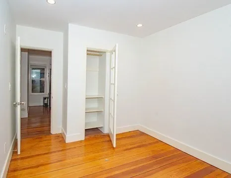 a view of empty room with wooden floor