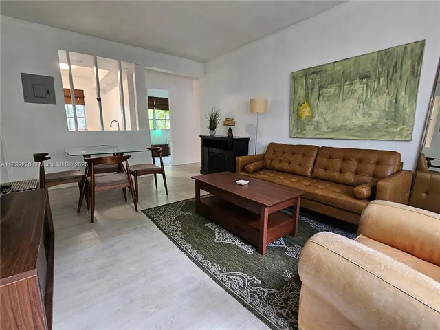 a living room with furniture a couch and a painting on the wall