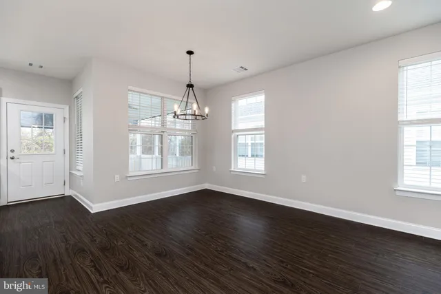 a kitchen with stainless steel appliances granite countertop a refrigerator a sink dishwasher a oven and white cabinets with wooden floor