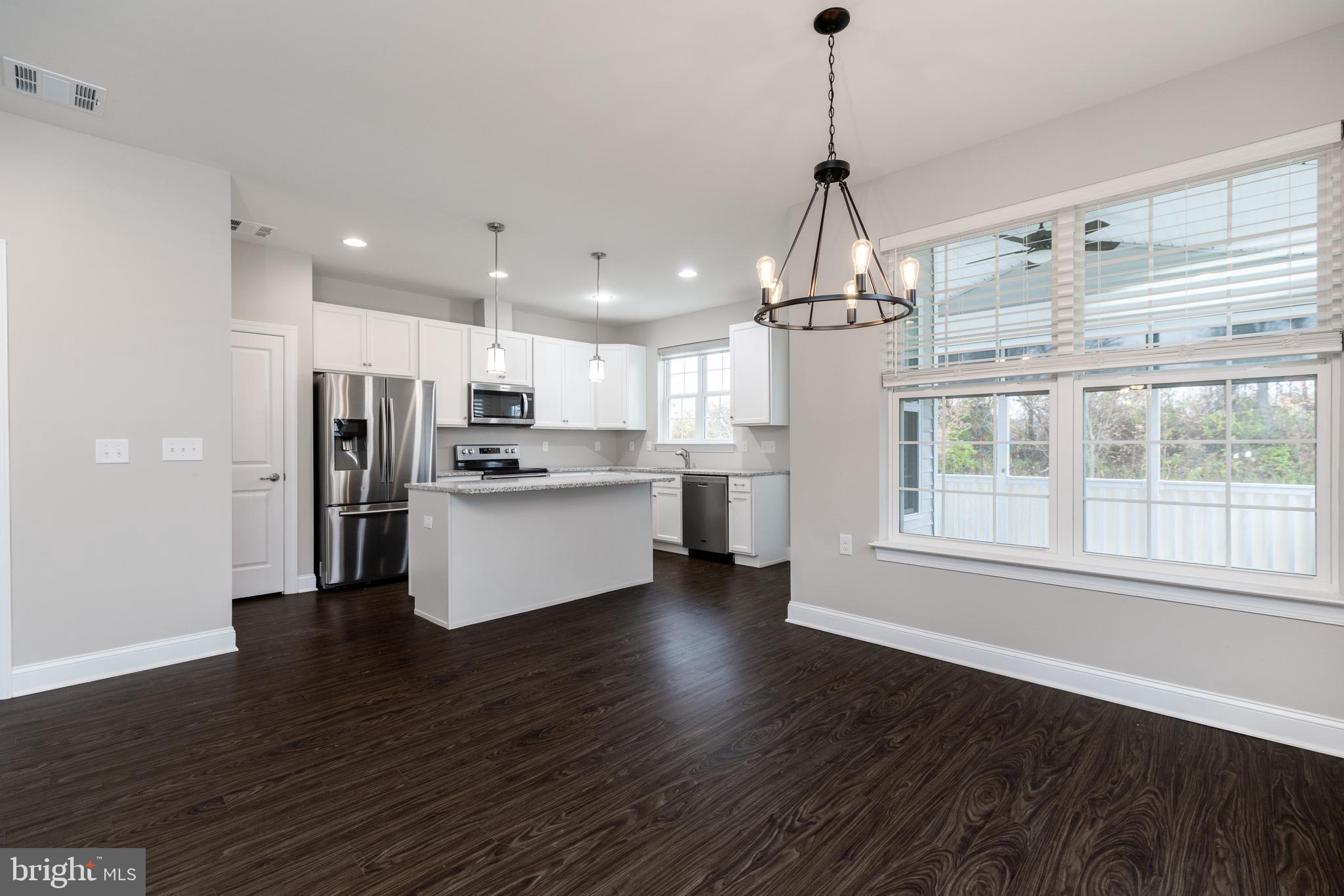 1415 Whispering Woods Road Middletown, DE 19709 - Photo 17 of 42 a kitchen with stainless steel appliances granite countertop a refrigerator a sink dishwasher a oven and white cabinets with wooden floor