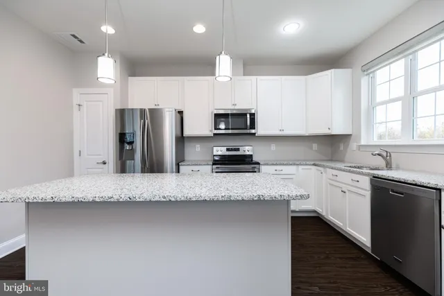 a kitchen with stainless steel appliances granite countertop a stove refrigerator sink and microwave