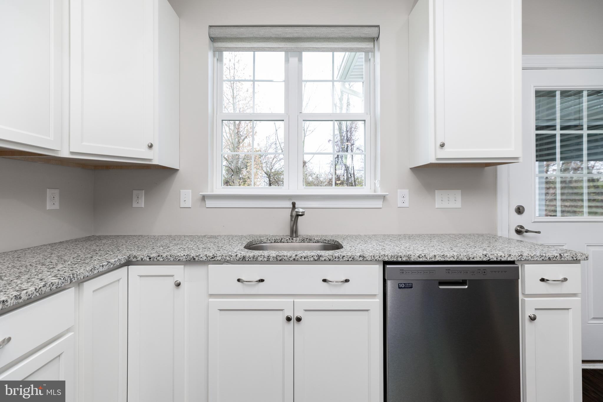 1415 Whispering Woods Road Middletown, DE 19709 - Photo 23 of 42 a kitchen with granite countertop white cabinets and a window