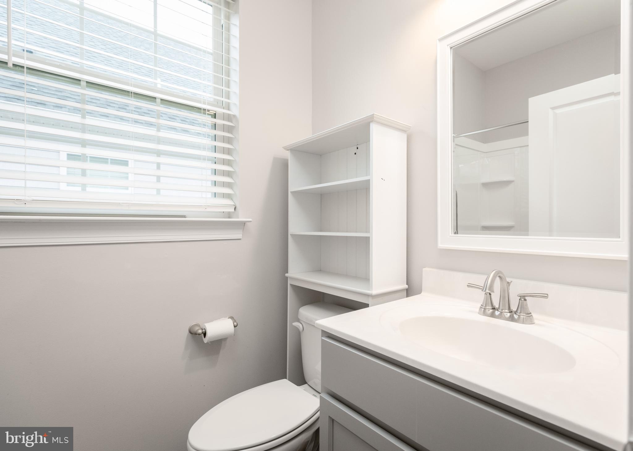1415 Whispering Woods Road Middletown, DE 19709 - Photo 34 of 42 a bathroom with a sink a toilet and a window