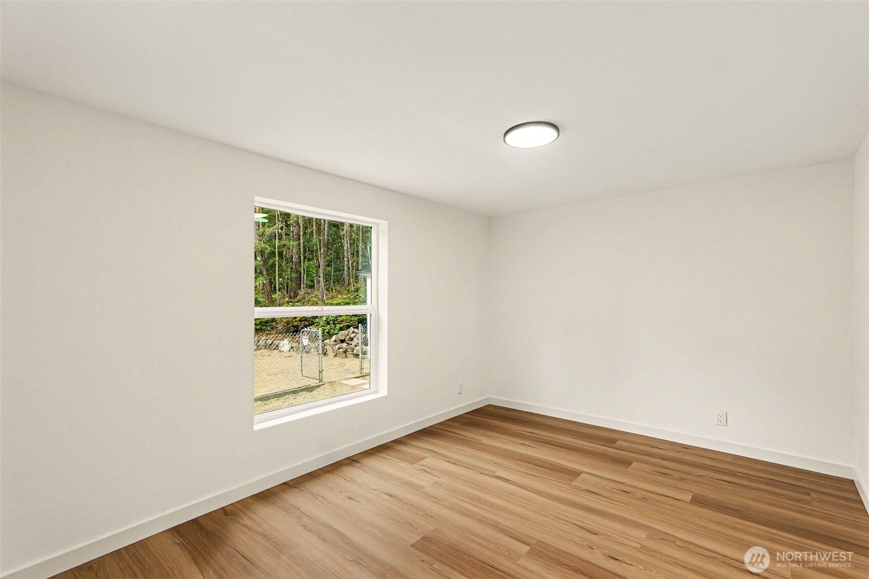 719 Tiedman Road Southwest Lakebay, WA 98349 - Photo 24 of 40 an empty room with wooden floor and windows