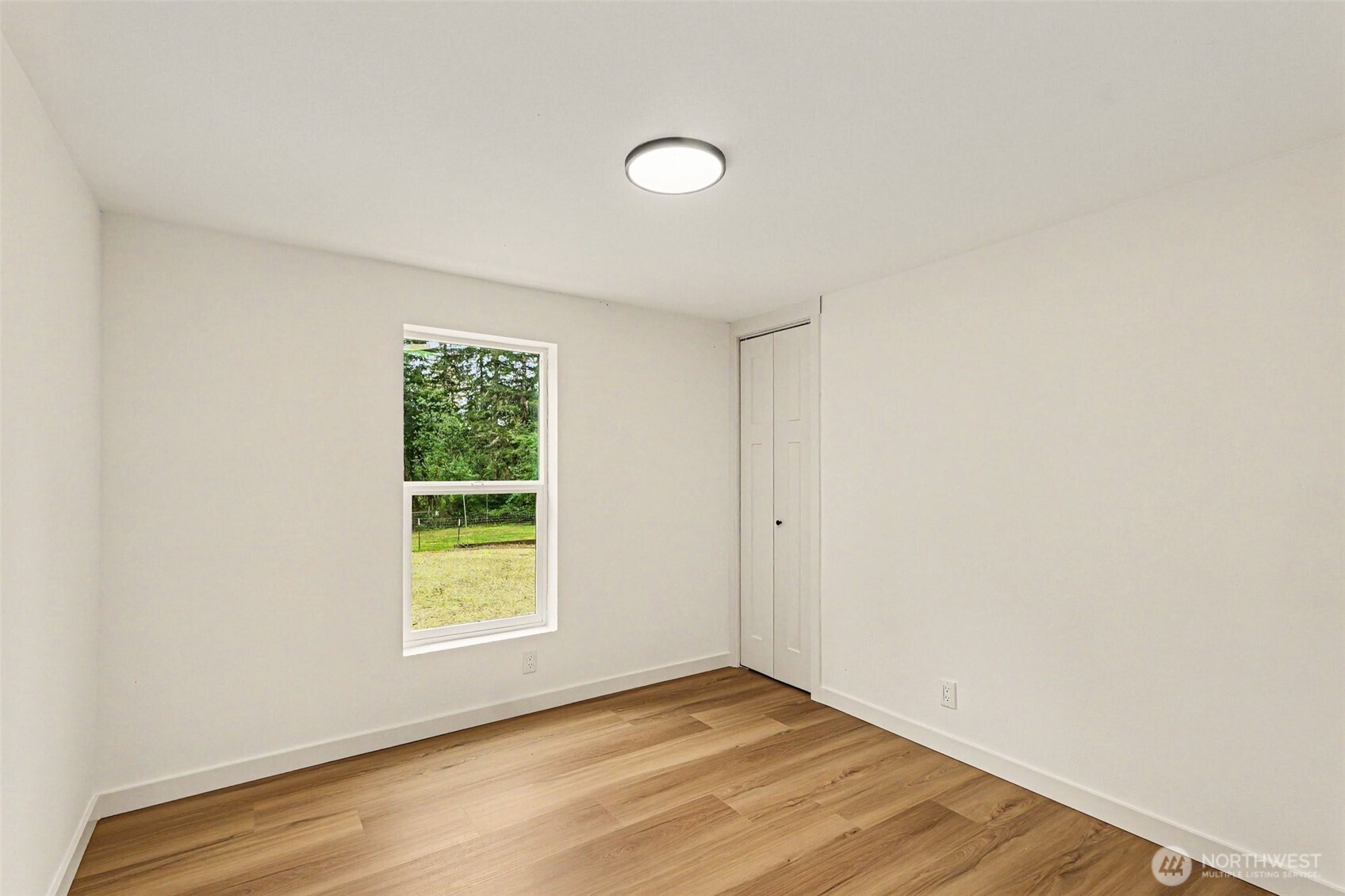 719 Tiedman Road Southwest Lakebay, WA 98349 - Photo 25 of 40 a view of an empty room with wooden floor and a window