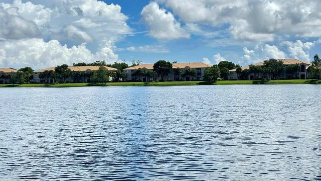 a view of a white house with a large window and wooden fence