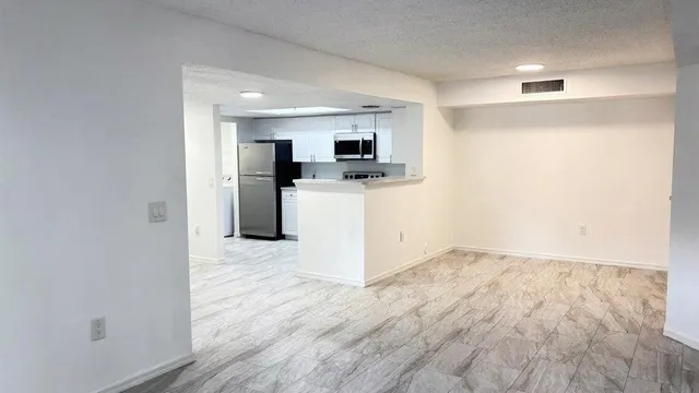 a view of a kitchen with a sink and a refrigerator