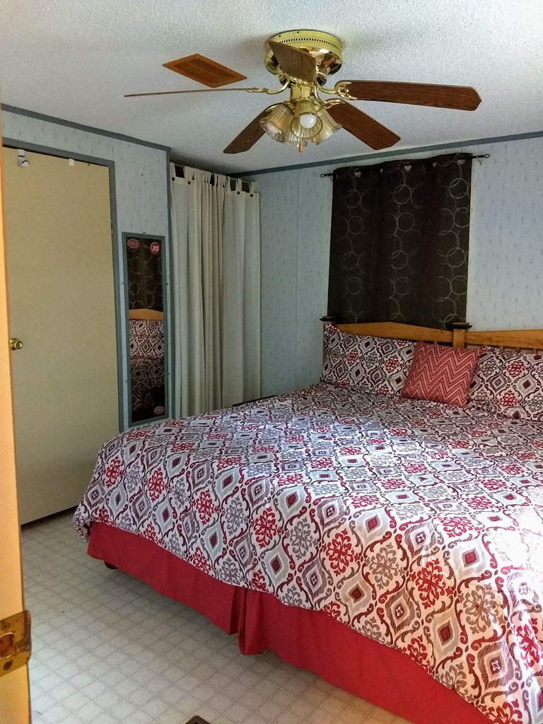 136 Redbud Lane Saluda, SC 29138 - Photo 7 of 17 a bedroom with a bed and a chandelier