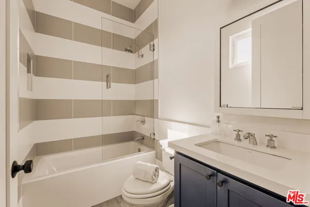 a bathroom with a sink toilet vanity and tub