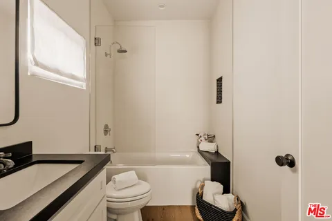 a bathroom with a granite countertop toilet a sink and a bathtub