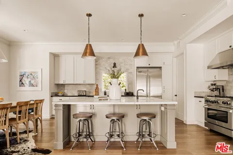 a view of a kitchen with kitchen island stainless steel appliances a sink and a stove