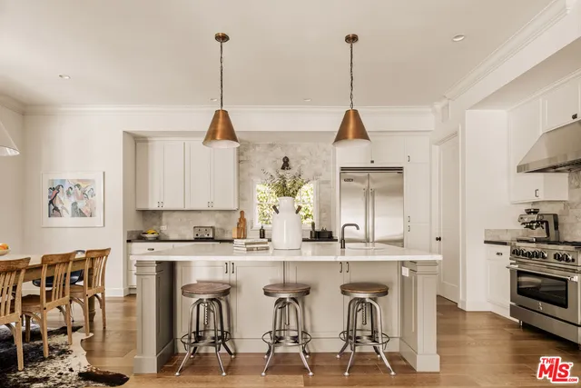 a view of a kitchen with kitchen island stainless steel appliances a sink and a stove