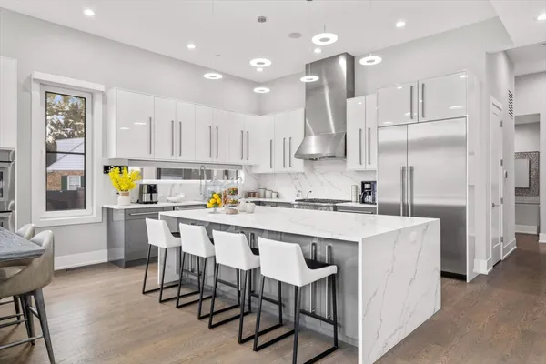 a kitchen with a sink a refrigerator and chairs