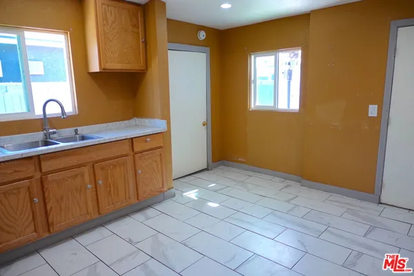 a view of a kitchen with wooden floor and cabinets