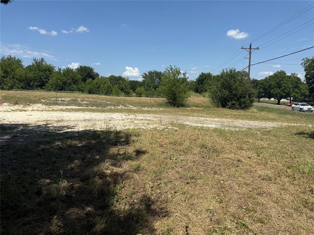 560 West New Hope Road West New Hope, TX 75071 - Photo 1 of 7 Expansive land parcel featuring natural ground cover, mature trees along the perimeter, and a clear blue sky overhead