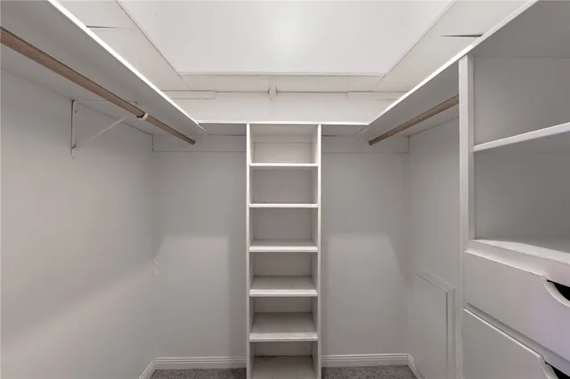 a view of walk in closet with empty racks