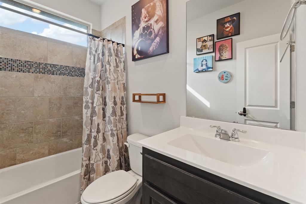1812 Millbrae Road Cleburne, TX 76033 - Photo 19 of 30 Bathtub with tile surround, mosaic accent band, and an elongated horizontal window
