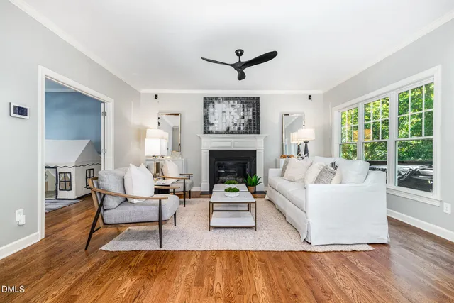 a living room with fireplace furniture and a large window