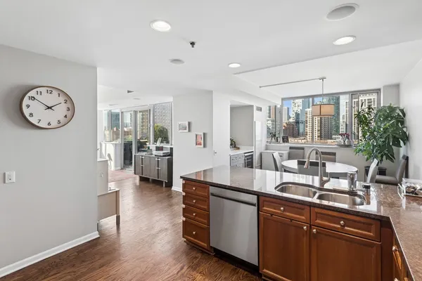 a dining hall with stainless steel appliances granite countertop a lot of counter space and wooden floor