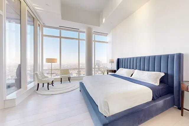 a spacious bedroom with a bed and a large window