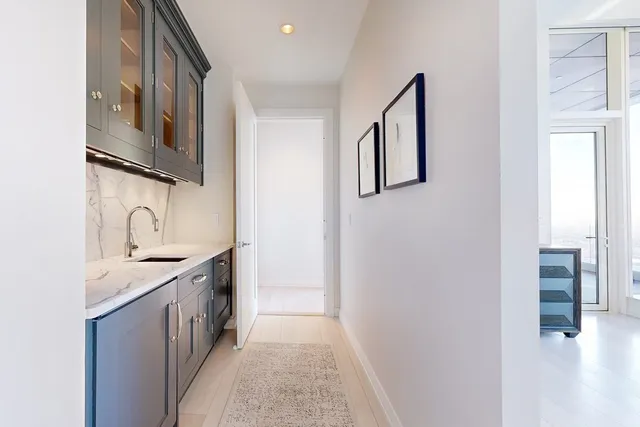 a hallway with sink and cabinets