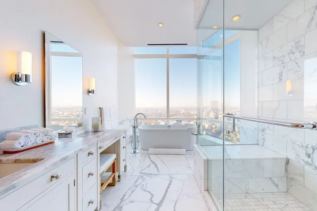 a bathroom with a double vanity sink a mirror and a bath tub