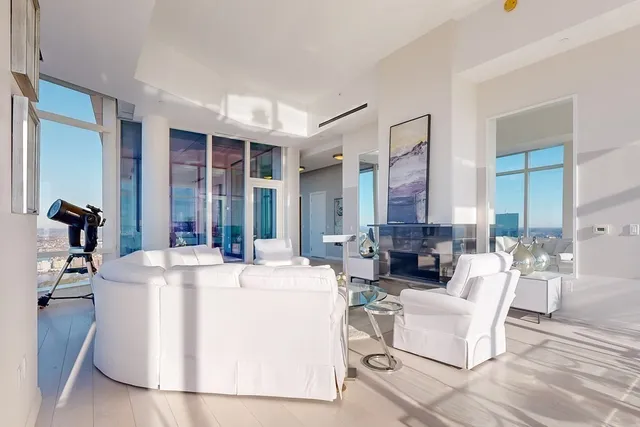 a living room with fireplace furniture and a large window