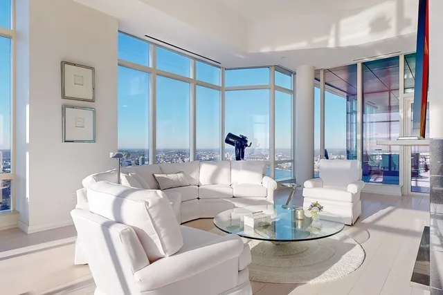 a dining room with couches a glass table and chairs