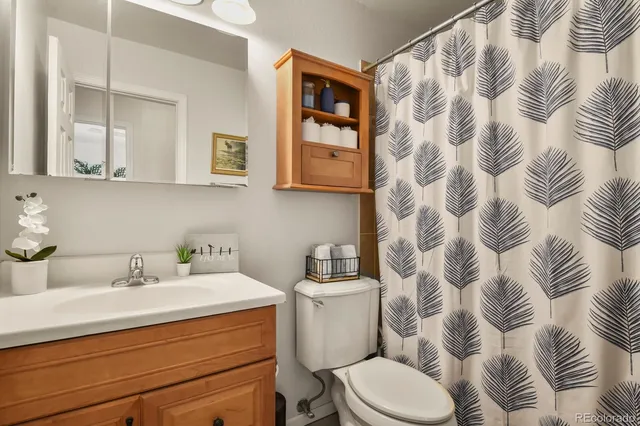 a bathroom with a sink and mirror with toilet
