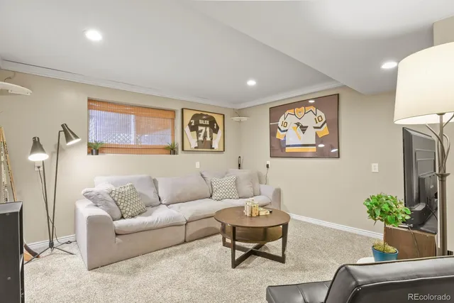 a living room with furniture and a painting on the wall