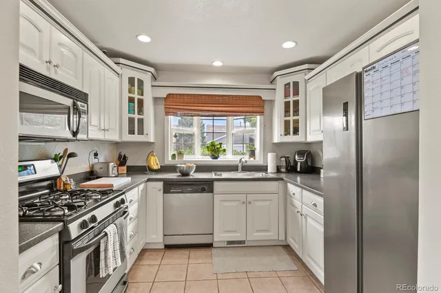 a kitchen with stainless steel appliances granite countertop a stove a sink dishwasher a refrigerator and cabinets with wooden floor