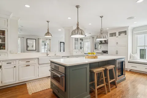 a kitchen with kitchen island granite countertop a sink a stove and a wooden floors