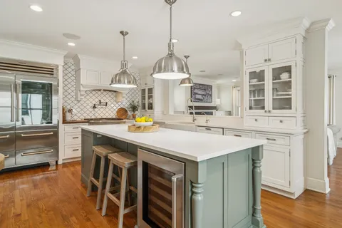 a kitchen with a sink a center island cabinets and a wooden floor