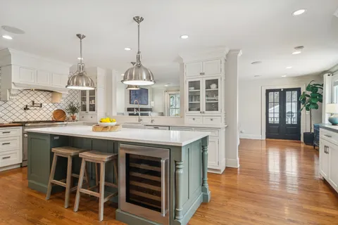 a kitchen with a sink chandelier and wooden floor